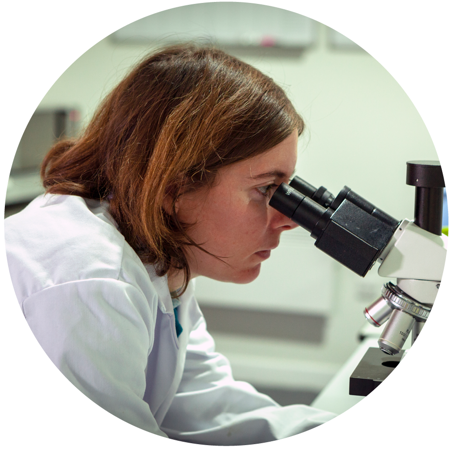 A technician looking into microscope