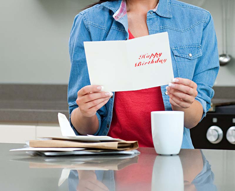 Image of someone holding and reading a greetings card