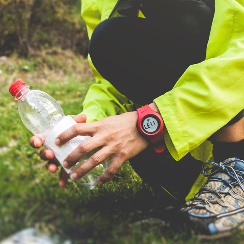 A person picking up a plastic bottle that has been littered