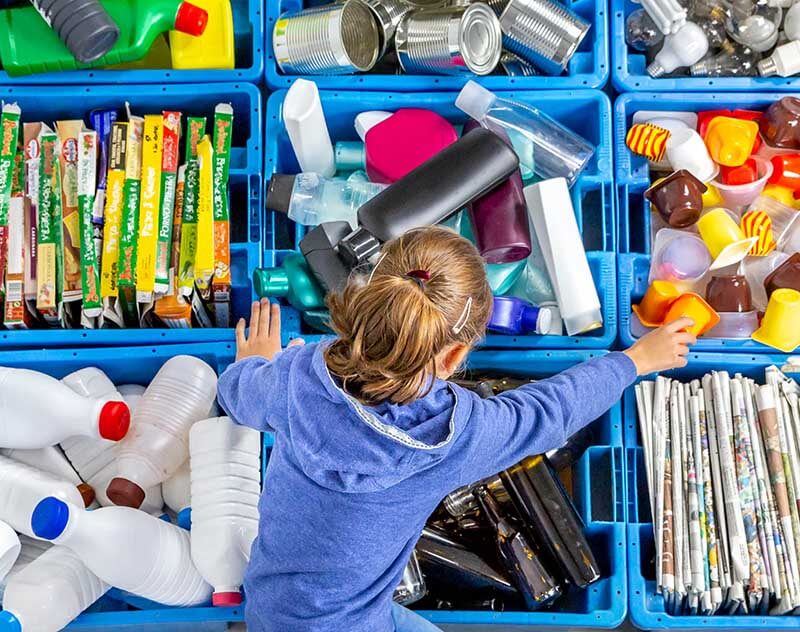 A child looking over boxes full of packaging waste