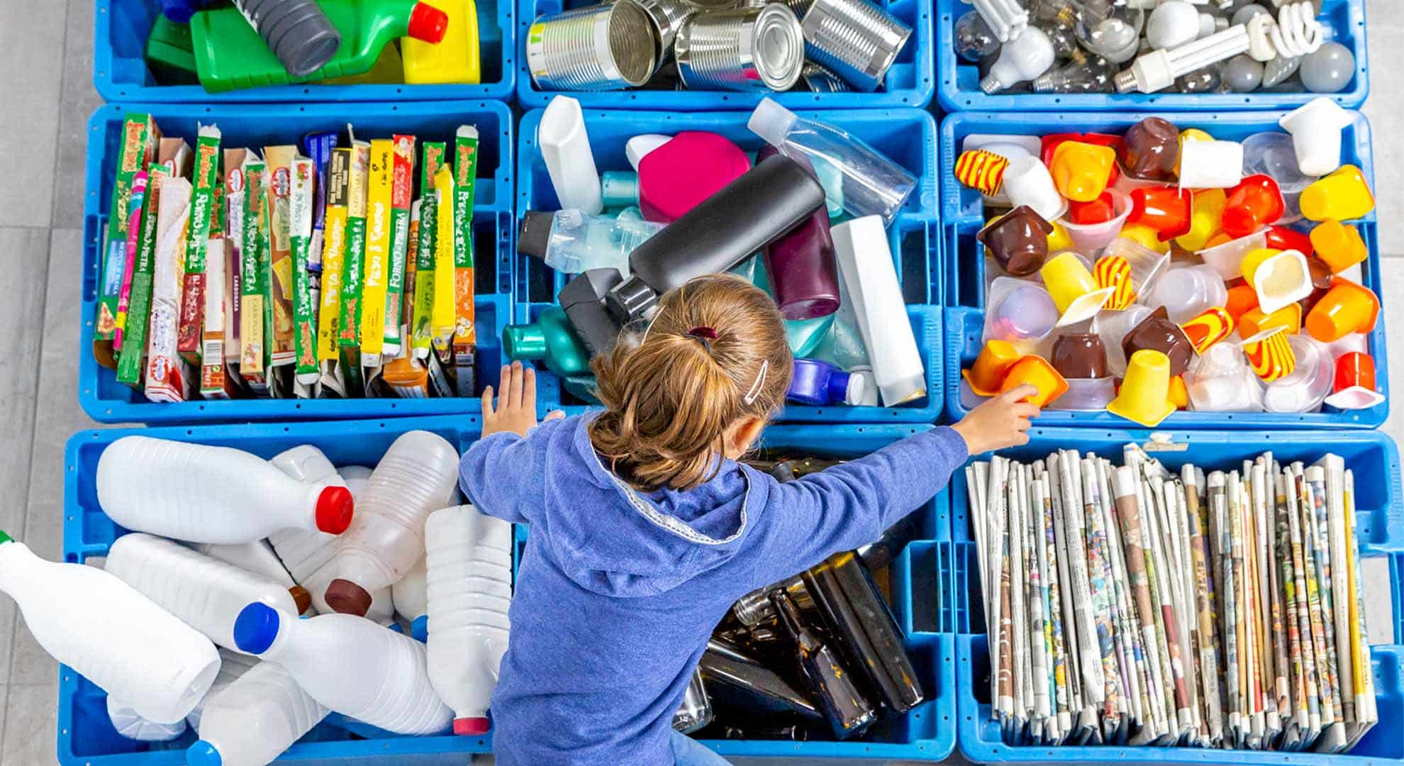 A child looking over boxes full of packaging waste