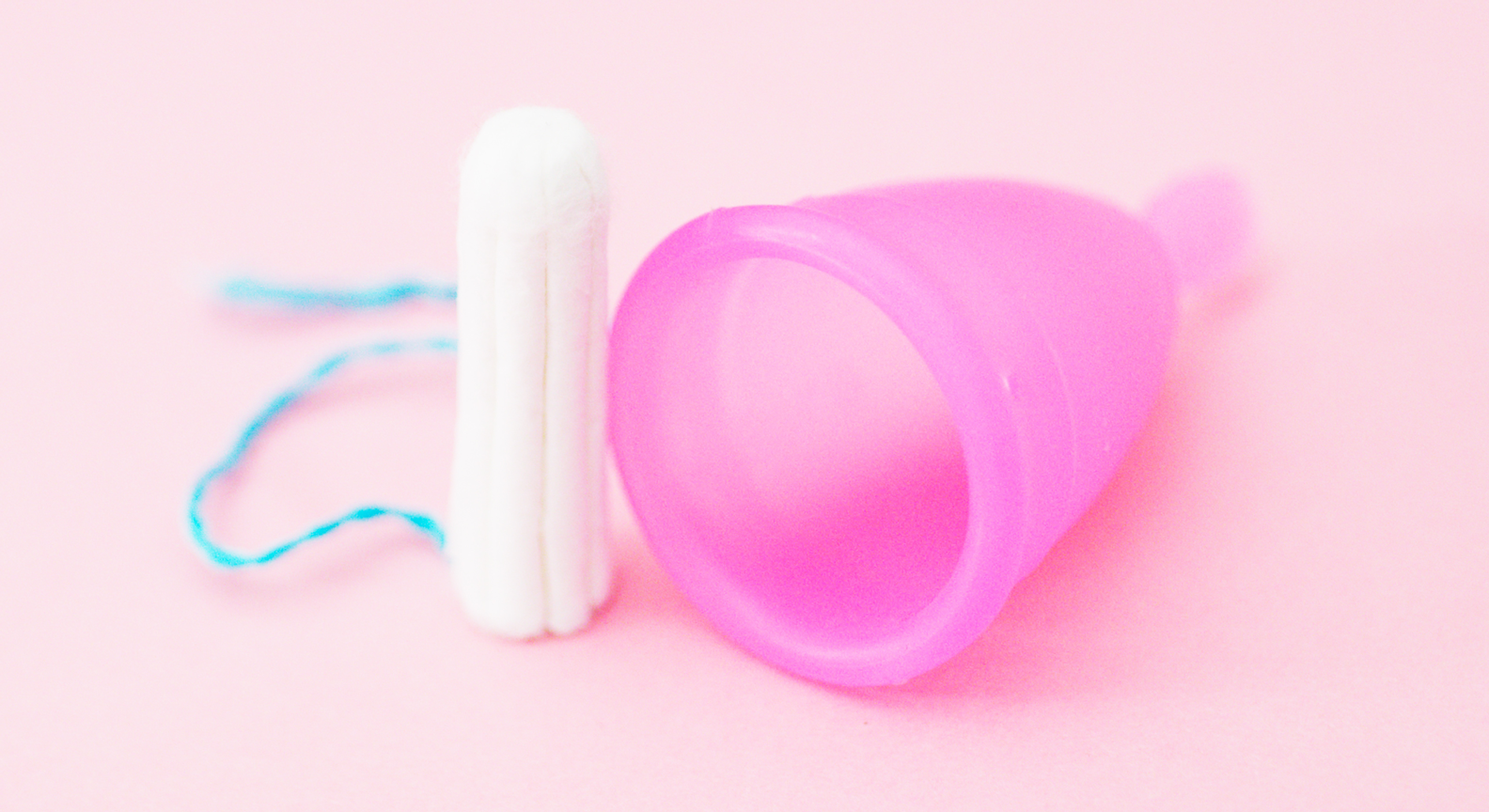 A disposable menstrual sanitary product alongside a reusable menstrual moon cup sanitary product