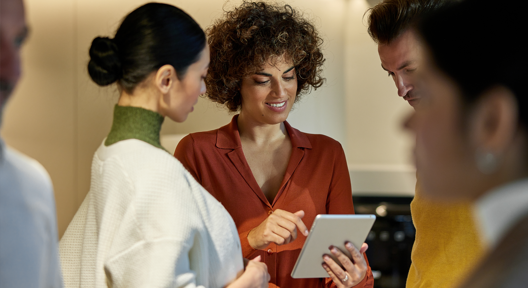 A group of people looking intently at a tablet screen