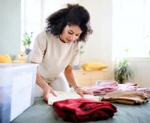 Photo of a person folding clothes while decluttering their home