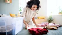 A person folding clothes while decluttering their home