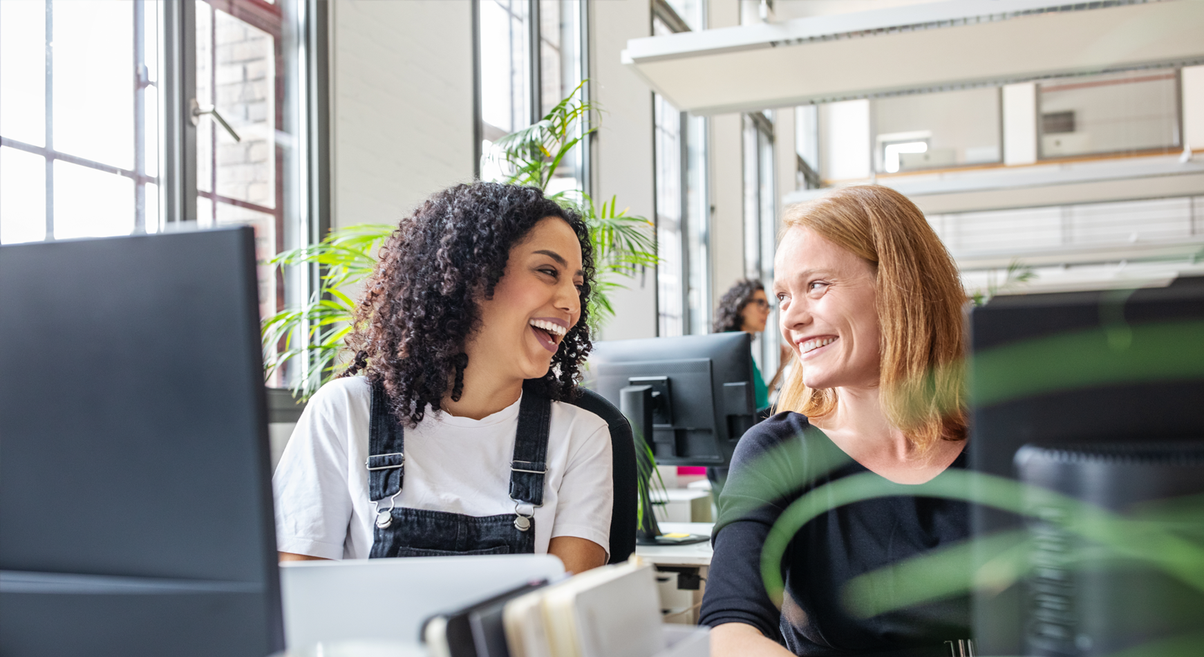 Two people sitting in front of a computer smiling