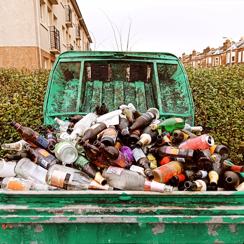 A large bin with various recyclable items flowing out the top