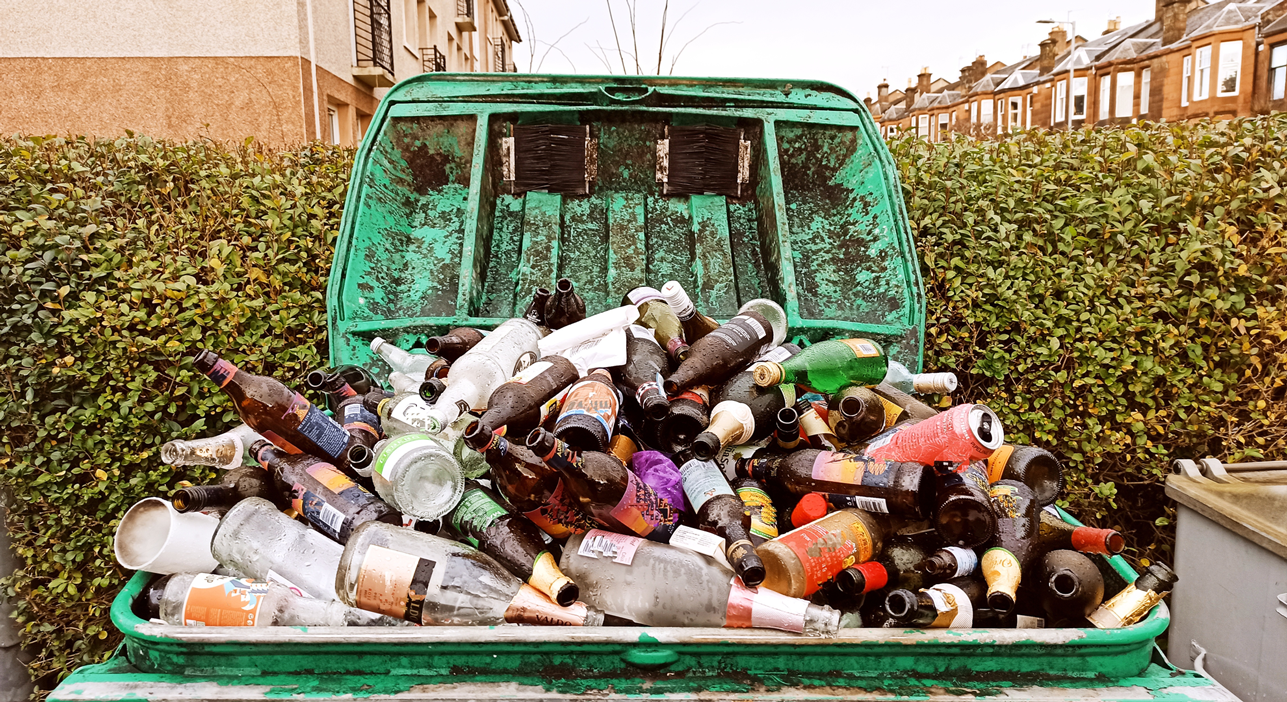 A large bin with various recyclable items flowing out the top