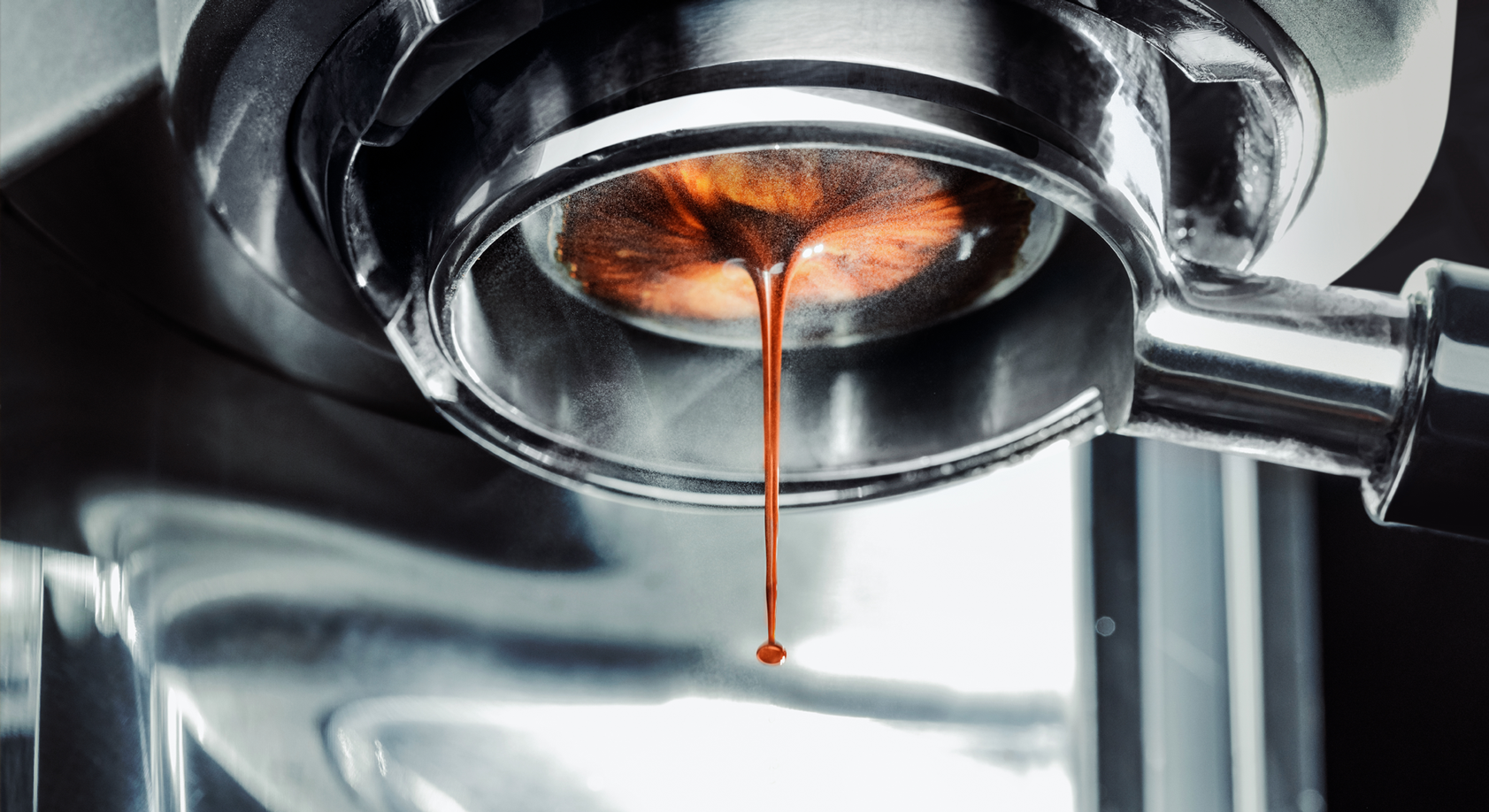 A coffee machine with fresh coffee flowing out of it