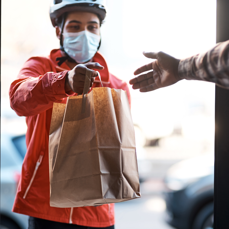 A delivery person handing over food at the door step