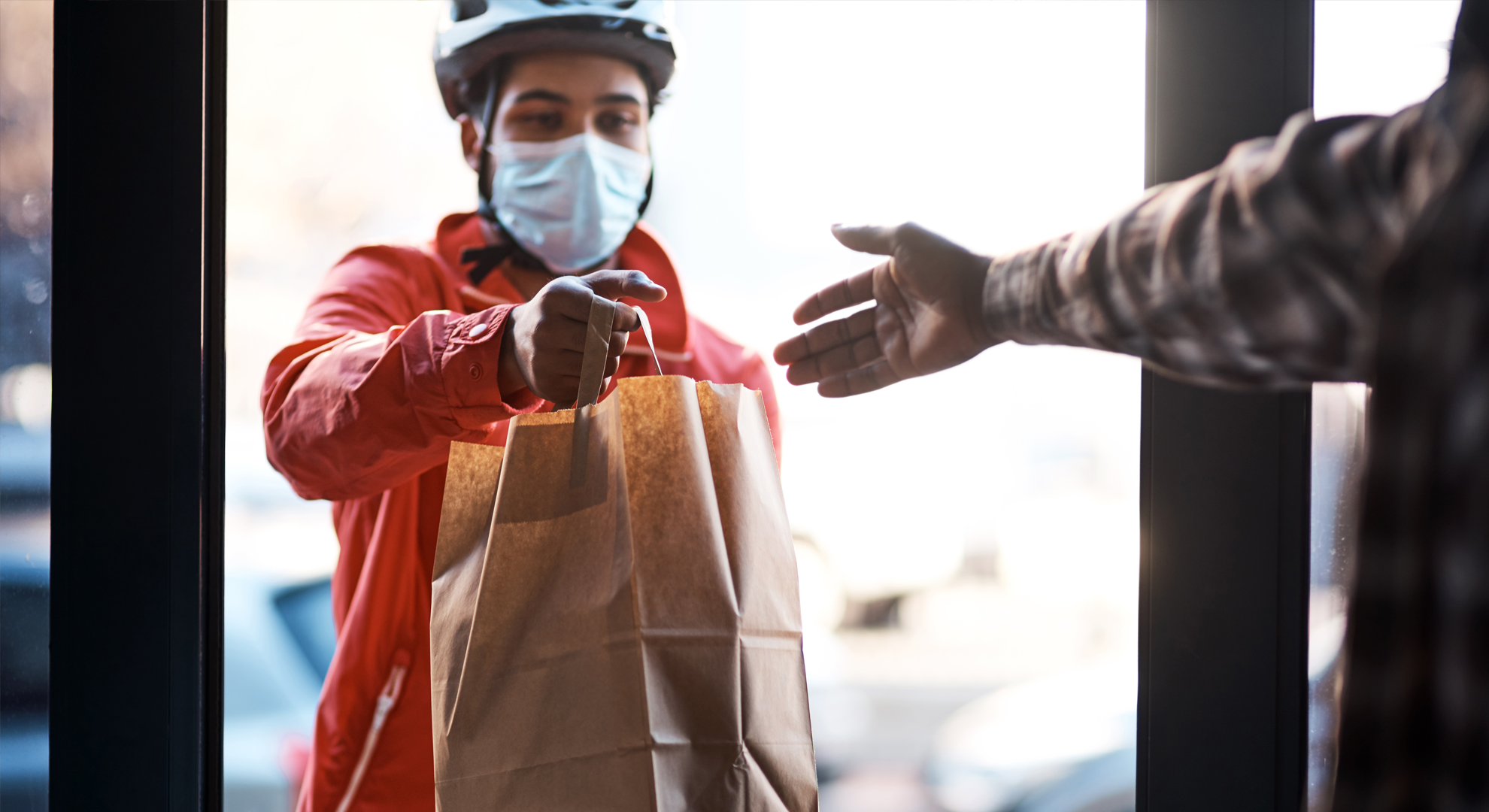 A delivery person handing over food at the door step