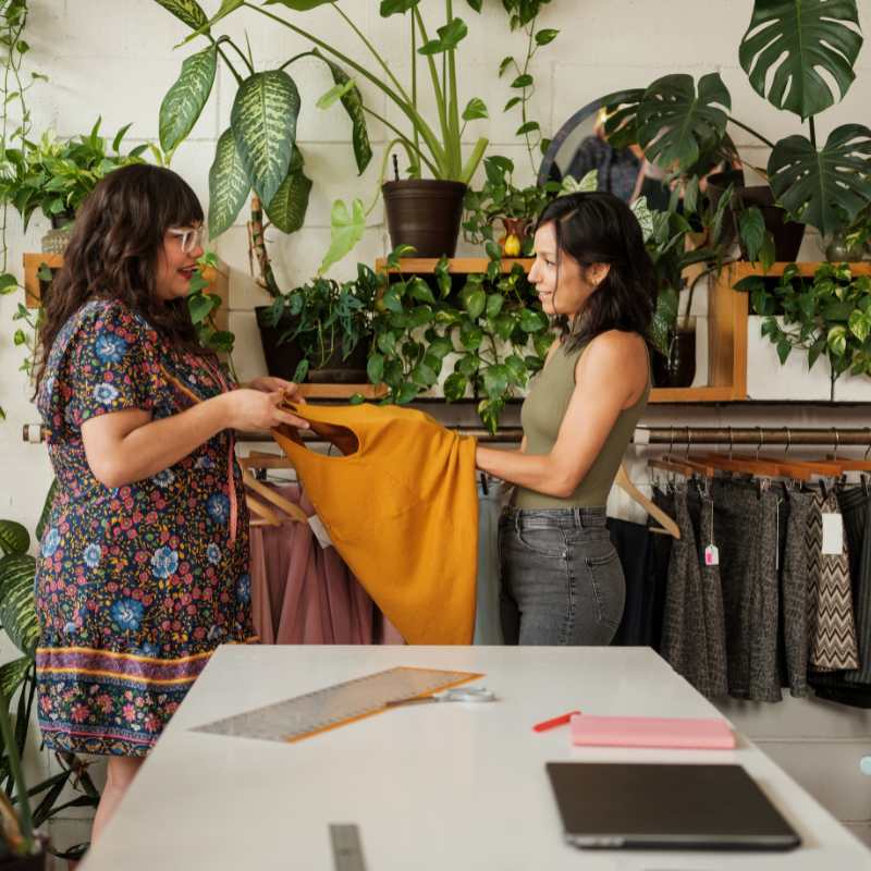 Image of women exchanging preloved clothes