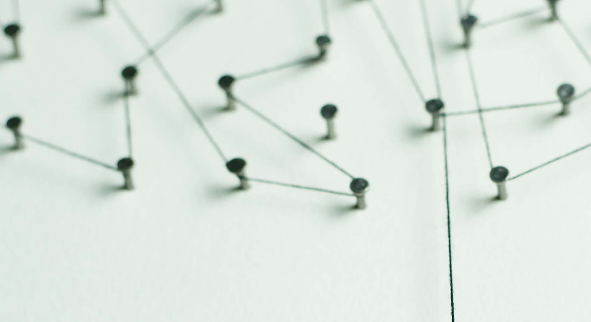 Nails on a light green board with string connecting them